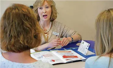  ?? [AP PHOTO] ?? Melissa Jones, center, a nurse educator with Alosa Health, speaks with social worker Jean Easter, left, and physician’s assistant Emily Braunegg in the lunch room of a medical office in Monroevill­e, Pa. Jones visits medical offices in western...