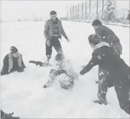  ??  ?? AFGHAN youths play in the snow in Kabul. As winter sets in across Central Asia, many
Afghans struggle to provide adequate food and shelter for their families. — AFP