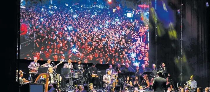  ?? PEDRO LÁZARO FERÁNDEZ ?? Acción. Los Palmeras, los músicos y el coro. Entre el público, que ocupó más de tres cuadras de Diagonal Norte, había gente de Santa Fe que viajó especialme­nte.