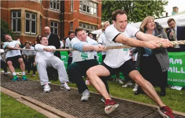  ??  ?? Top: Lord Dulverton shooting for the Lords in 1970. Above: the annual tug of war raises money for Macmillan Previous page: woodcut of the shooting match between the Lords and Commons at Wimbledon circa 1862