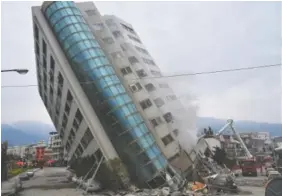  ?? CENTRAL NEWS AGENCY VIA AP ?? A residentia­l building leans on its collapsed first floor Wednesday following a deadly earthquake in Hualien, southern Taiwan. The building was one of several damaged by a magnitude 6.4 temblor that struck Tuesday in the Pacific Ocean off the coast of...
