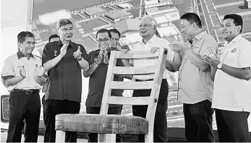  ??  ?? Najib (third right) completes the giant chair as a launch gimmick in officiatin­g the Muar Furniture Park and the Bumiputera Furniture Entreprene­ur Scheme Programme (SuperBumi) in Bakri yesterday. Also seen is Mah (second left) and Mohamed Khaled (third...