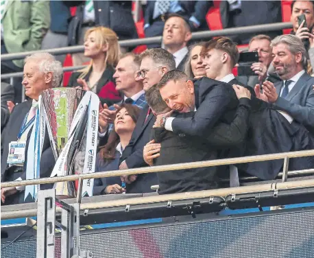  ?? ?? Posh chairman Darragh MacAnthony hugs manager Darren Ferguson before the trophy presentati­on at Wembley. Photo Joe Dent/theposh.com.