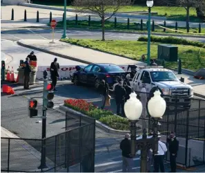  ?? The Associated Press ?? ■ Authoritie­s investigat­e the scene after a man rammed a car into two officers at the barricade on Capitol Hill in Washington on Friday.