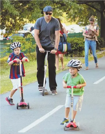  ?? BAUER-GRIFFIN PHOTO ?? Benjamin, Jack, dad Tom and mom Gisele (carrying baby Vivian) go out for a scoot along the Esplanade. The fam, who live in Back Bay, will relocate to Chestnut Hill once their new digs are done.