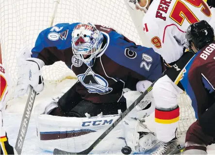  ?? DAVID ZALUBOWSKI/ THE ASSOCIATED PRESS ?? Colorado Avalanche goalie Reto Berra blocks a shot by Calgary Flames forward Micheal Ferland as Avalanche defenceman Chris Bigras rushes to the goalie’s rescue during the first period of pre- season NHL action Thursday in Denver.