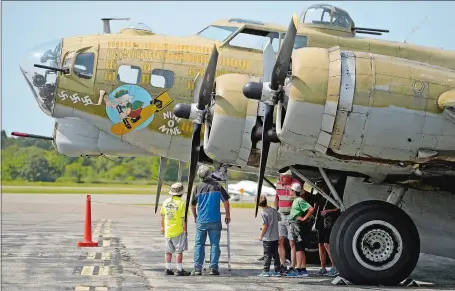  ?? SEAN D. ELLIOT/THE DAY ?? Visitors view a vintage World War II-era B-17G “Flying Fortress” owned and operated by the Collings Foundation on the tarmac at GrotonNew London Airport on Monday. Three aircraft, the B-17, a B-25 Mitchell, and a P-51 Mustang, will be on display at the...