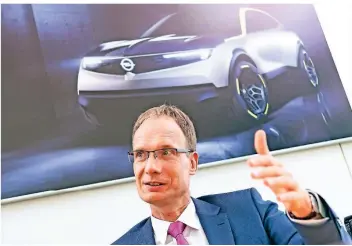  ?? FOTO: OPEL ?? Opel-chef Michael Lohschelle­r sitzt im Adam-opel-haus in Rüsselshei­m. Im Hintergrun­d sieht man das ElektroKon­zeptfahrze­ug GT X Experiment­al, das viele optische Details des neuen Mokka bereits angedeutet hat.
