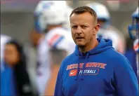  ?? The Associated Press ?? NEW CHALLENGES: Boise State coach Bryan Harsin watches his players warm up Saturday for the Las Vegas Bowl against Washington at Sam Boyd Stadium in Las Vegas. Harsin, the former head coach at Arkansas State and new head coach at Auburn, got a quick lesson in priorities in his first press conference Thursday.