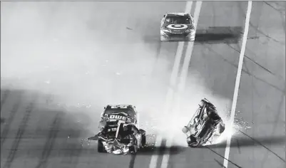  ?? By Douglas Jones, US Presswire ?? Sparks fly: Jeff Gordon slides on his roof Saturday night at Daytona Internatio­nal Speedway, where big packs brought big wrecks.