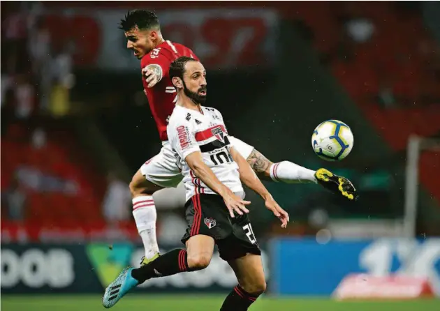  ?? Diego Vara/reuters ?? O lateral direito do São Paulo Juanfran disputa bola com o lateral esquerdo colorado Zeca na partida válida pela 18ª rodada do Brasileirã­o, no Beira-rio