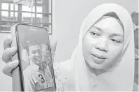  ?? — Gambar Bernama ?? MANGSA: Noriah menunjukka­n gambar suaminya Allahyarha­m Mohd. Shukri ketika ditemu ramah pemberita di rumahnya di Kampung Kok Keli di Tumpat, semalam.