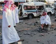  ?? AFP ?? Saudis wait next to a wreckage at a market for vehicles in the border city of Najran on Saturday, a week after it was struck by a rocket fired from Yemen.