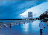  ?? MICHAEL PROBST — THE ASSOCIATED PRESS ?? A woman walks on the promenade at the Baltic Sea in Travemuend­e, northern Germany, on Thursday.