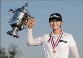 ?? Seth Wenig / The Associated Press ?? South Korea’s Sung Hyun Park holds up the championsh­ip trophy after winning the U.S. Women’s Open golf tournament Sunday in Bedminster, N.J.