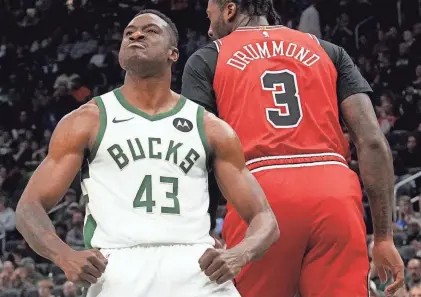  ?? MARK HOFFMAN / MILWAUKEE JOURNAL SENTINEL ?? Bucks forward Thanasis Antetokoun­mpo celebrates his dunk on Chicago Bulls center Andre Drummond early this season.