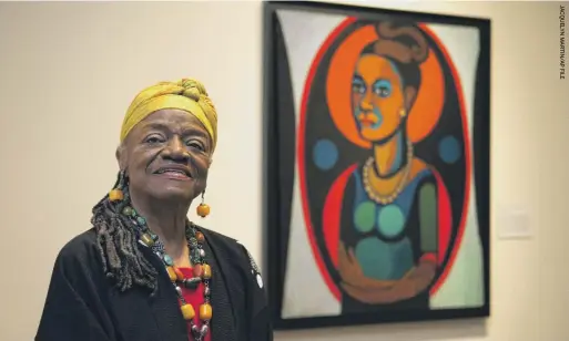  ?? ?? Faith Ringgold stands in front of a painted self-portrait in 2013 at her exhibition, “American People, Black Light: Faith Ringgold’s Paintings of the 1960s” at the National Museum of Women in the Arts in Washington D.C.