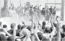  ?? Haidar Mohammed Ali / AFP/ Getty ?? Iraqi protesters celebrate after they breached a concrete wall surroundin­g the parliament and broke into Baghdad’s fortified “Green Zone” on Saturday.