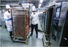  ?? Victor Besa / The National ?? Chefs at Erth Abu Dhabi hotel prepare chicken for biryani meals as part of the iftar programme