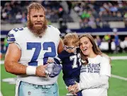  ?? [AP PHOTO] ?? Dallas Cowboys center Travis Frederick and his wife Kaylee, right, pose for a photo with their son Oliver, last season before a game in Arlington, Texas. Frederick is battling a rare neurologic­al disorder and the Cowboys begin their season without their stalwart at center.