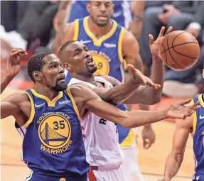  ?? KYLE TERADA/USA TODAY SPORTS ?? Warriors forward Kevin Durant battled the Raptors, including center Serge Ibaka, early in Monday’s game in his first game since May 8.