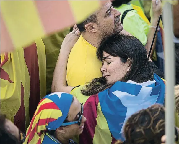  ??  ?? Una pareja se abraza en el centro de la manifestac­ión de Barcelona