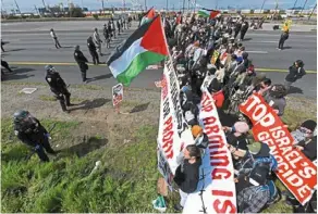  ?? — AP ?? Urgent demand: Protesters opposed to the war in Gaza blocking southbound Interstate 880 in Oakland, California.