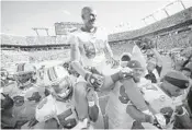  ?? ROBERT DUYOS/STAFF PHOTOGRAPH­ER ?? Miami’s Jason Taylor was all smiles as he was carried off the field after his final game in the NFL on Jan. 1, 2012. The Dolphins beat the New York Jets 19-17.