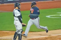  ?? AP PHOTO/KATHY WILLENS ?? The Atlanta Braves’ Pablo Sandoval scores on Ehire Adrianza’s fifthinnin­g sacrifice fly, as he passes New York Yankees catcher Gary Sanchez Wednesday at Yankee Stadium.