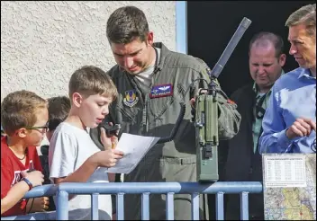  ?? Photos courtesy of Edwards Air Force Base ?? Maj. Ben Gilliland, Orange Flag director, 411th Flight Test Squadron, assists a STARBASE Edwards student on providing coordinate­s to an airborne fighter pilot during an Orange Flag exercise at Edwards Air Force Base on Dec. 10.