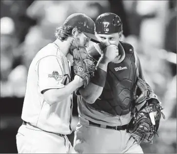  ?? Elsa Garrison
Getty Images ?? CLAYTON KERSHAW, left, and A.J. Ellis confer during the Dodgers’ 3-1 victory over the Mets to force a Game 5. Kershaw allowed three hits and one run in seven innings to snap a five-game postseason losing streak.