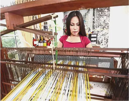  ??  ?? ‘You can try whatever you want. But you must have your fundamenta­ls, the foundation of your work,’ says Anne, working at her KL home studio’s loom, which she uses to create her distinct woven works. — ONG SOON HIN/The Star