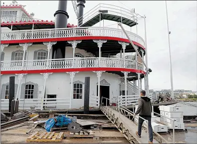  ?? AP/GERALD HERBERT ?? Matt Dow, project manager for the restoratio­n of the City of New Orleans riverboat, walks onto the vessel in New Orleans.