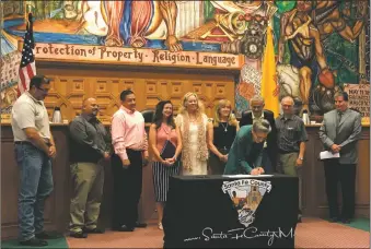  ?? COURTESY PHOTO ?? Sharron Welsh, executive director of The Housing Trust, signs the memorandum; behind her are County Commission­er Robert Anaya; County Commission­er Henry Roybal; Paco Arguello, Santa Fe Associatio­n of Realtors executive vice president; Melissa...