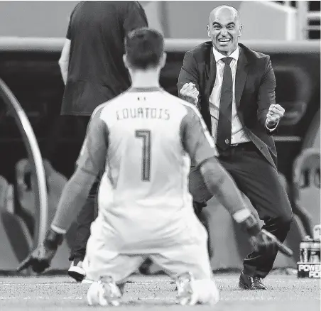  ?? Catherine Ivill / Getty Images ?? Coach Roberto Martinez, right, joins Thibaut Courtois in celebratin­g Belgium’s victory over Japan in the second round.