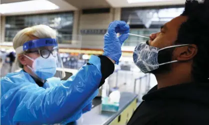  ?? Photograph: Mario Tama/Getty Images ?? A man receives a nasal swab test at LAX airport in Los Angeles.Tennessee and California have become the new US centers, according to Johns Hopkins.