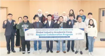  ?? ?? Mayor Choi Choong-gyu (fourth from left) taking a commemorat­ive photo with UMS students and officials who visited the Daedeok-gu youth bunker.