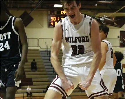  ?? MATTHEW MOWERY — MEDIANEWS GROUP ?? Milford’s Sam Lewis (32) celebrates a late basket by teammate Owen Stark in a Lakes Valley Conference basketball game against Waterford Mott on Friday. Lewis had 29points as the Mavericks knocked off the defending champion Corsairs, 65-47.