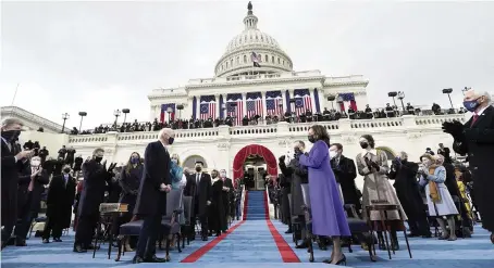  ?? ANDREW HARNIK
Pool photo via The New York Times ?? Attendees applaud as President-elect Joe Biden arrives for his inaugurati­on at the Capitol in Washington on Wednesday.