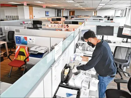  ?? PHOTOS BY HYOSUB SHIN / HYOSUB.SHIN@AJC.COM ?? Derek Outlaw, customer care coach, processes renewal forms in a nearly empty customer care center at Gas South headquarte­rs in Cobb County.