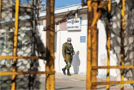 ?? AP ?? An Israeli soldier walks near a checkpoint at the Rosh Hanikra border crossing between Israel and Lebanon. The first round of talks between the two countries held on Wednesday.