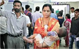  ??  ?? A woman carries her son injured in cross-border firing to a hospital, in Jammu on Wednesday