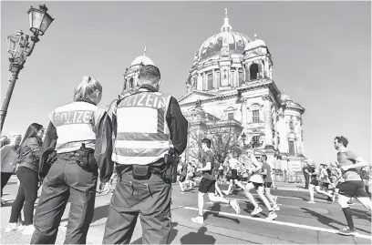  ?? — Gambar AFP ?? SERANGAN DIPINTAS: Anggota polis berkawal semasa acara separa maraton di Berlin, kelmarin.