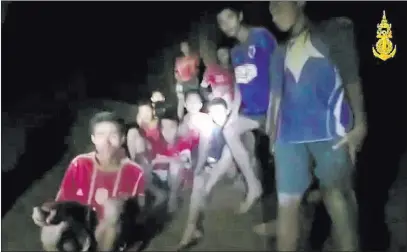  ??  ?? Thai Navy Seals In a video screen grab, a soccer team of 12 boys and their coach wait to be extricated from a cave Monday in Chiang Rai, Thailand.