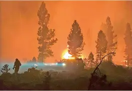  ?? — AFP/US FOREST SERVICE/HANDOUT ?? This handout photo, courtesy of the US Forest Service shows a firefighte­r and rig at the Bootleg Fire, near Klamath Falls, Oregon.