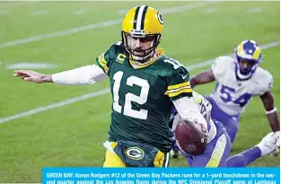  ??  ?? GREEN BAY: Aaron Rodgers #12 of the Green Bay Packers runs for a 1-yard touchdown in the second quarter against the Los Angeles Rams during the NFC Divisional Playoff game at Lambeau Field on Saturday in Green Bay, Wisconsin. —AFP