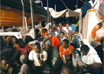  ??  ?? Picture taken on and released by German NGO ‘Mission Lifeline’ off the coast of Malta shows migrants sitting on board the Lifeline ship. — AFP photo