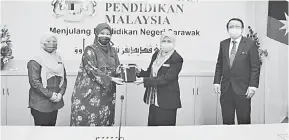  ??  ?? KELAI NEMUAI: Dr. Norsiah (dua ari kanan) nerima tepa ari pada Nor Dalila ngarika bala Direktor Kolej Komuniti Sarawak. Sama bisi dipeda dia Direktor Kolej Komuniti Kuching, Suharyati (kiri) enggau Sapit Direktor Sektor Pengatur Sekula, JPNS, Omar Mahli (kanan).