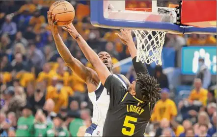  ?? Ezra Shaw / Getty Images ?? Dorian Finney-smith, left, of the Dallas Mavericks drives to the basket against Kevon Looney, 5, of the Golden State Warriors during the first quarter of Game Five. The Warriors will host either Boston or Miami on June 2.