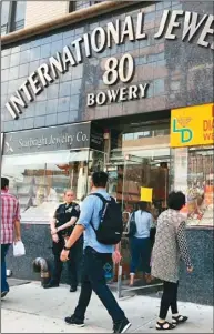  ??  ?? 被搶的華埠珠寶店19­日正常營業，警方繼續派人把守。 （記者金春香／攝影）